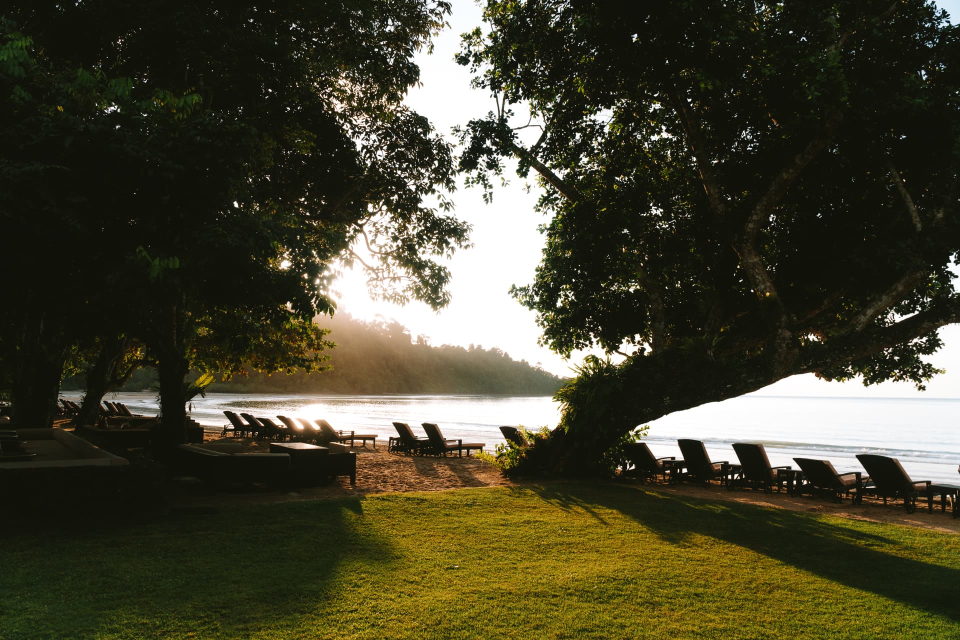 Golden light washes over beach loungers at the Datai Langkawi
